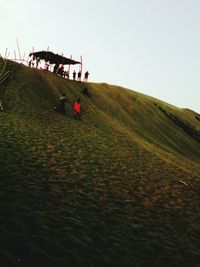 People on landscape against clear sky