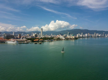 Sailboats in marina bay against sky