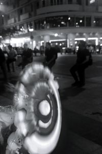 Blurred motion of people walking on illuminated city street