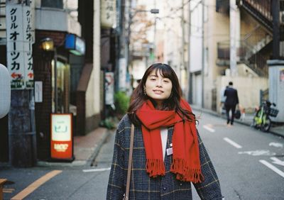 Portrait of woman standing on street in city