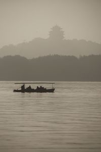 Silhouette boat in lake against sky