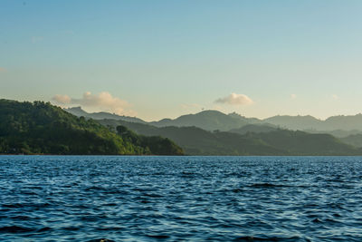 Scenic view of river and mountains against sky