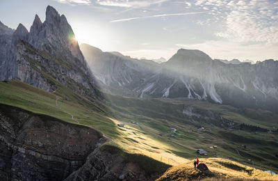 Rear view of man walking on mountain against sky