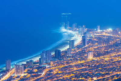 Aerial view of illuminated buildings in city at night