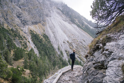 Full length of woman standing on mountain ridge