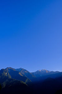 Scenic view of mountains against clear blue sky