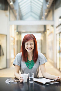 Portrait of happy mid adult woman having coffee in restaurant