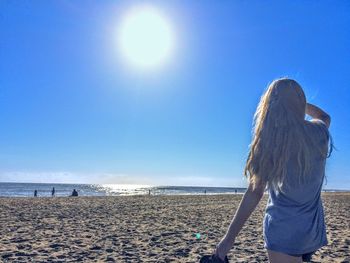 Blonde-haired adolescent female gazing towards the atlantic ocean 