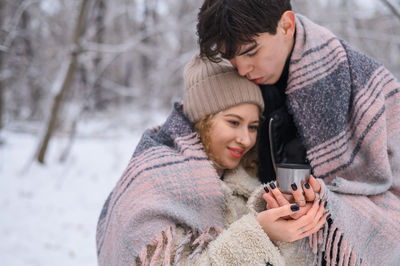 Young couple embracing outdoors during winter