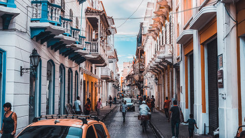 People walking on street amidst buildings in city