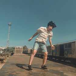 Full length of young man standing against sky