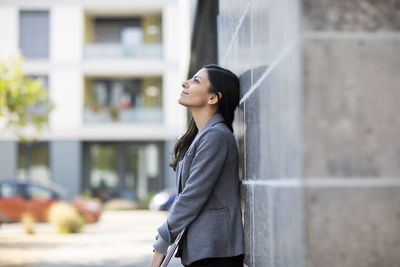 Side view of a smiling young woman looking away