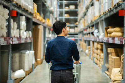 Rear view of man standing in warehouse