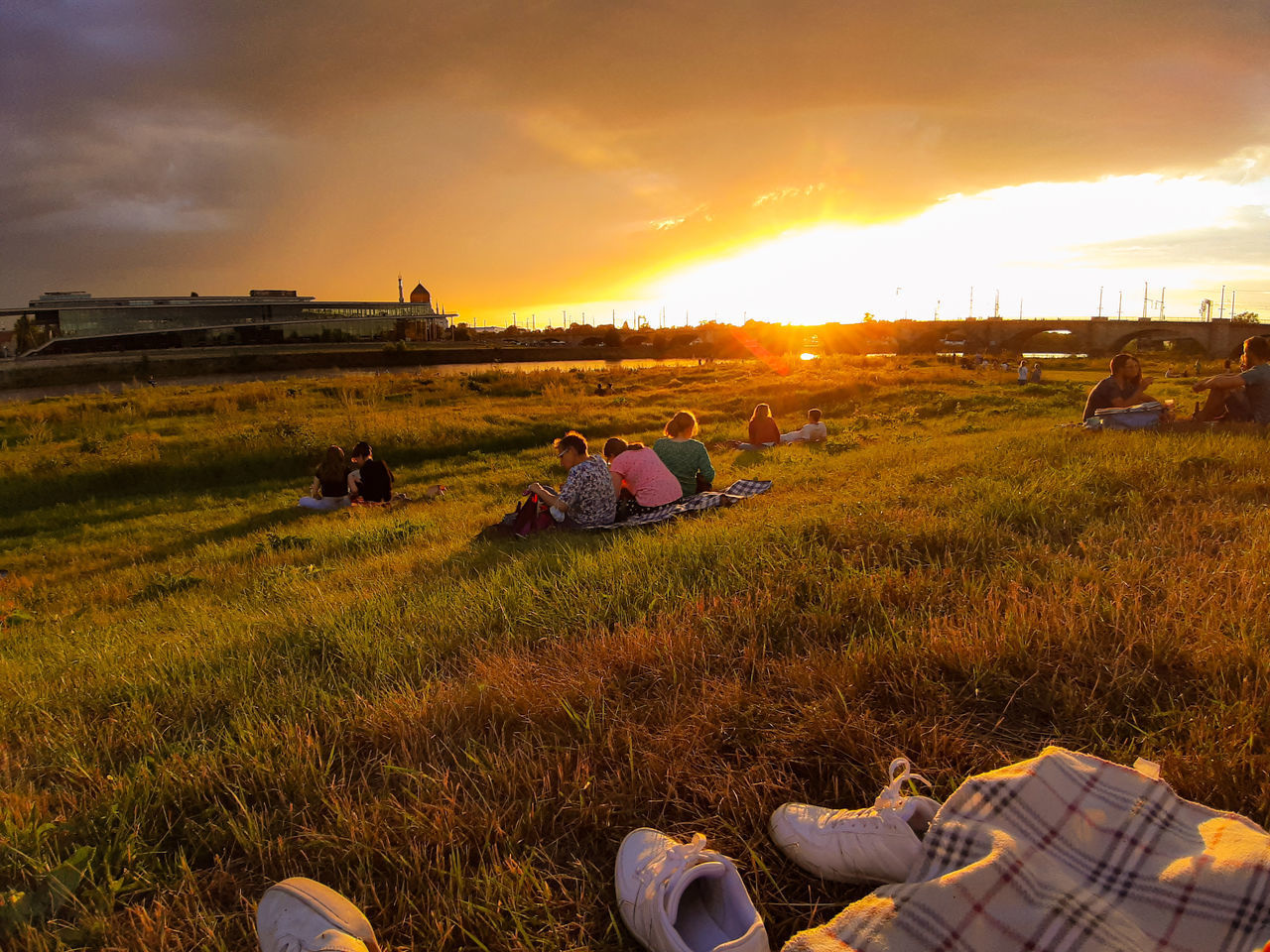 PEOPLE ON FIELD AGAINST SUNSET SKY