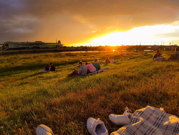 People on field against sky during sunset