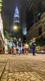 People on street amidst buildings in city