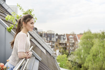 Smiling young woman standing on balcony