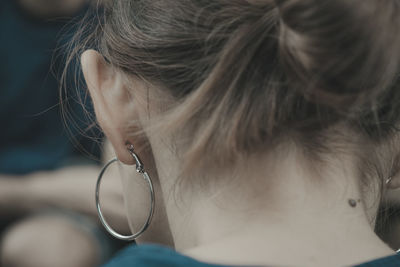 Close-up rear view of woman wearing earring