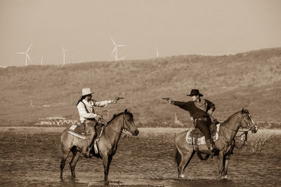 People riding horse cart on field