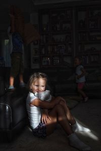 Cute girl sitting on sofa at home