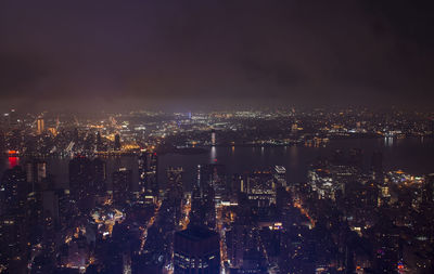 High angle view of illuminated cityscape against sky at night