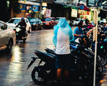 Rear view of people walking on street in city