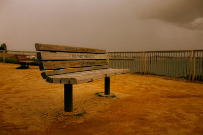 Empty bench against sky