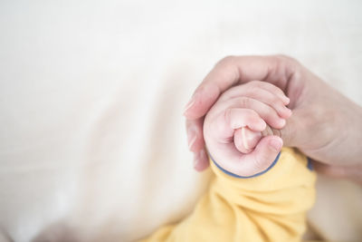 Midsection of child holding hands