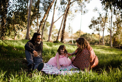 Aunt, uncle and niece having picnic in field