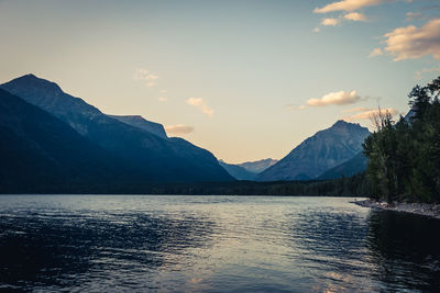 Scenic view of lake by mountains against sky