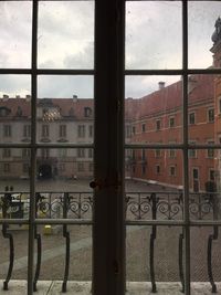 Buildings against sky seen through glass window