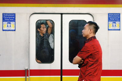 Full length of woman standing in train