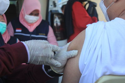 A man is being vaccinated by medic in public vaccination.