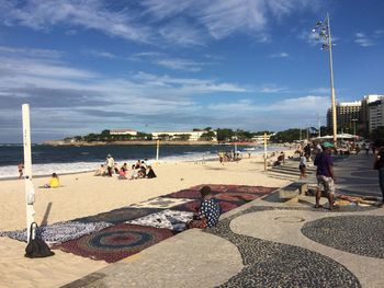 People at beach against sky