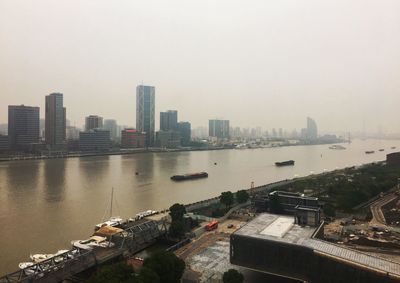 High angle view of river and cityscape against clear sky