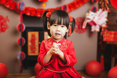 Portrait of cute girl holding red umbrella