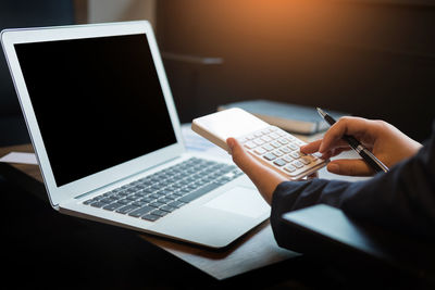 Low section of person using laptop on table