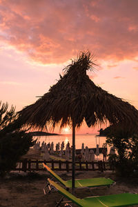 Palm trees on beach against sky during sunset