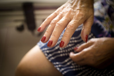 Midsection of woman showing nail polish on hand
