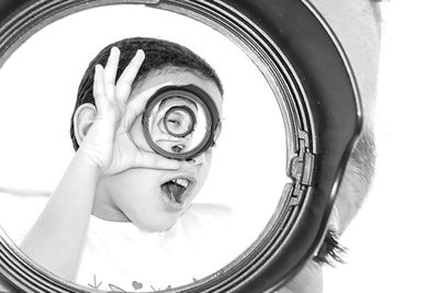 Low angle view of girl looking through a lens cap