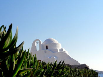 Low angle view of bell tower against clear sky on sunny day