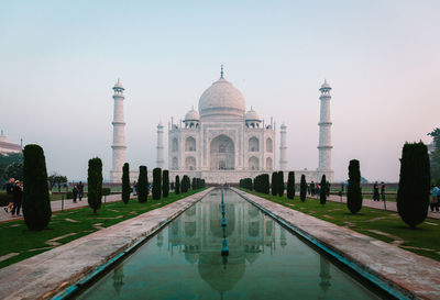 Reflection of taj mahal in pond against clear sky