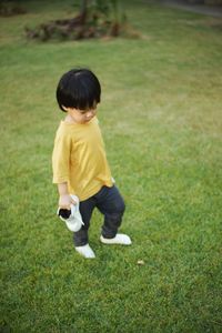 Side view of young woman standing on grassy field