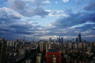 View of cityscape against cloudy sky