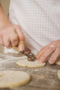 Cropped image of hand making cookies on table