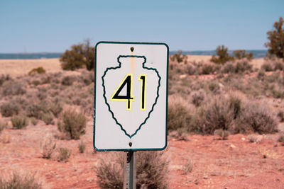 Information sign on road against sky