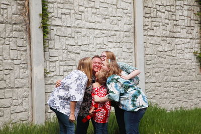 Lesbian couples with boy against wall