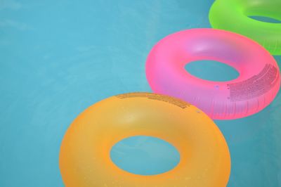 High angle view of colorful inflatable rings on swimming pool