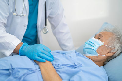 Midsection of doctor examining patient in hospital