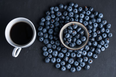 High angle view of blueberries with coffee on table